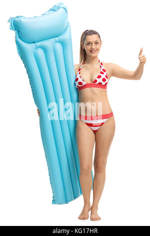 Full length portrait of a young woman with an air mattress making a thumb up sign isolated on white background Stock Photo