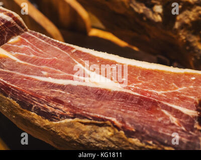 Jamon serrano. Traditional Spanish ham in the market close up. Pork leg ham on table. Meat in restaurant interior. Whole jamon on stand. Selective foc Stock Photo