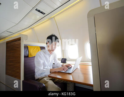 Asian man working on first class airplane Stock Photo