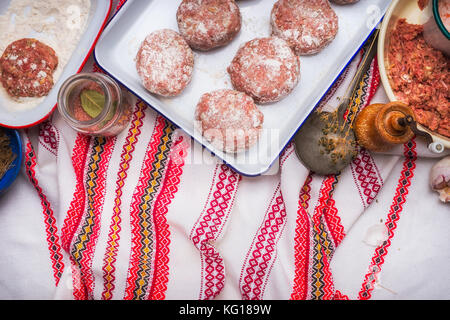 Meat patties cooking preparation with minced meat, flour and seasoning on traditional kitchen napkin , top view Stock Photo