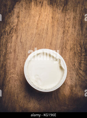 Yogurt  in plastic cup  on rustic wooden background, top view Stock Photo