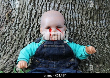 Bloody Boy Doll in Overalls by Tree Stock Photo