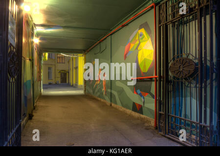 St. Petersburg, Russia - June 23, 2016: Illuminated arch with street art in old apartment building Stock Photo