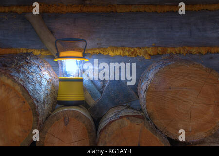Luminous hand lantern and axe standing on the lumber Stock Photo