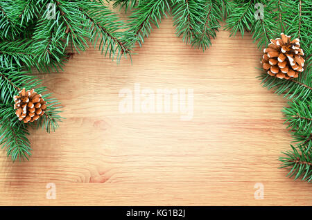 Fir tree branch on brown wooden background. Top view with copy space. Stock Photo