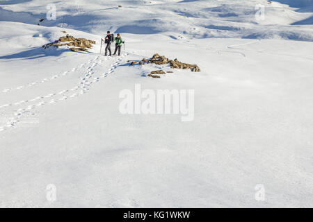 Senior couple is snowshoe hiking in alpine winter mountains. Bavaria, Germany. Stock Photo
