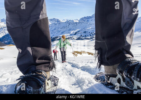 Senior couple is snowshoe hiking in alpine winter mountains. Bavaria, Germany. Stock Photo