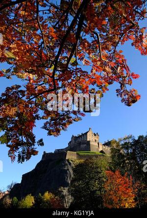 Edinburgh Castle is surrounded by the Autumn colours of the trees in Princes Street Gardens. Stock Photo