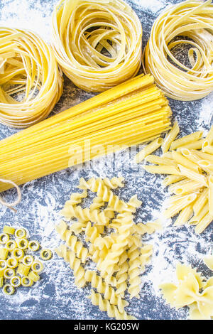 Various mix of pasta on a gray concrete background. Diet and food concept Stock Photo