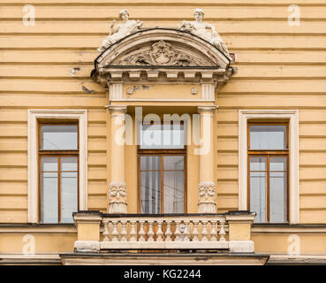 Three windows in a row and balcony on facade of urban office building front view, St. Petersburg, Russia Stock Photo