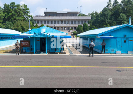 JSA within DMZ, Korea - September 8 2017: UN soldiers and soldiers in front of blue buildings at North South Korean border with North Korean tourists  Stock Photo