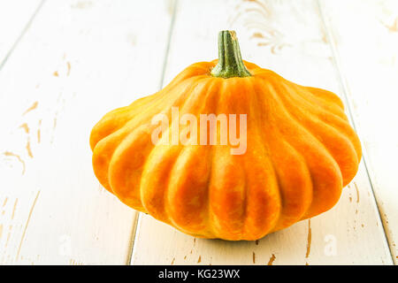 Pumpkin patty pan on a white wooden table. Autumn harvest. Stock Photo