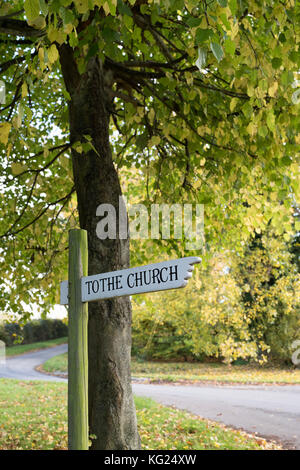 To the 13th century Church of St Swithun sign post at Compton Beauchamp in autumn. Vale of White Horse, Oxfordshire, England Stock Photo