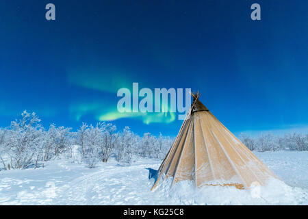 Isolated Sami tent in the snow under Northern Lights (Aurora Borealis), Abisko, Kiruna Municipality, Norrbotten County, Lapland, Sweden Stock Photo
