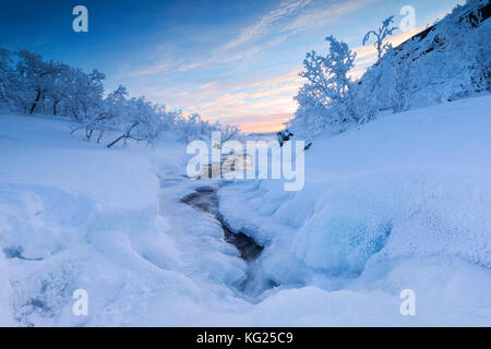 Sunrise on the frozen river and forest, Abisko, Kiruna Municipality, Norrbotten County, Lapland, Sweden, Scandinavia, Europe Stock Photo
