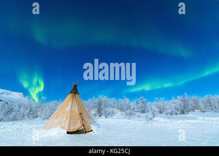Isolated Sami tent in the snow under Northern Lights (Aurora Borealis), Abisko, Kiruna Municipality, Norrbotten County, Lapland, Sweden, Scandinavia Stock Photo