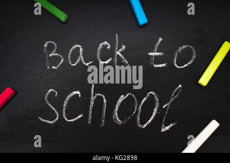 Back to school message on Blackboard inscribed with colorful chalk for background Stock Photo