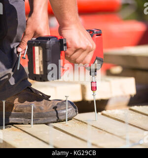 Carpenter working with an electric screwdriver. Stock Photo