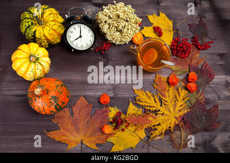 Autumnal vegetables and leaves on dark wood Stock Photo