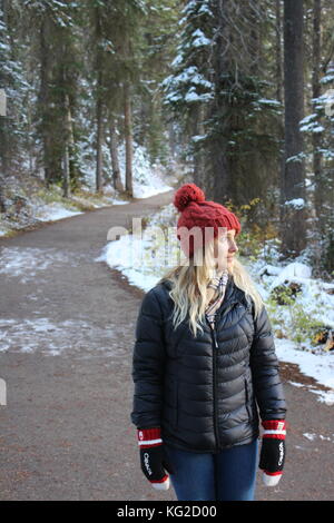 Blonde girl in winter clothing exploring the trails around Emerald Lake, Alberta. Stock Photo