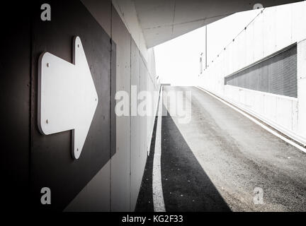 Underground parking garage exit with arrow signal. Space for text. Stock Photo