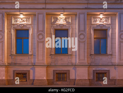 Three windows in a row on night illuminated facade of the Institute of Oriental Manuscripts front view, St. Petersburg, Russia Stock Photo
