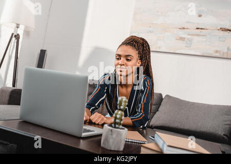 woman using laptop on couch Stock Photo