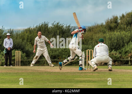 A batsman plays a shot during a Sunday League match between two local Cricket teams. Stock Photo