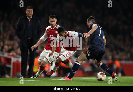 Arsenal's Theo Walcott (centre) and Red Star Belgrade's Marko Gobeljic battle for the ball during the UEFA Europa League match at the Emirates Stadium, London. Stock Photo