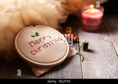 work in progress /embroidered Merry christmas wishes on frame/ winter cozy evening Stock Photo