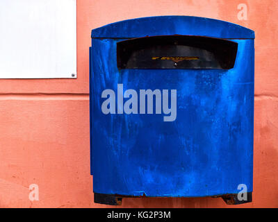 Rusty blue mailbox on the flat peachy wall Stock Photo