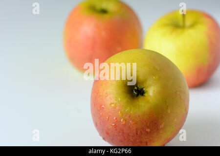 Three red and yelllow apples on white background - close-up Stock Photo