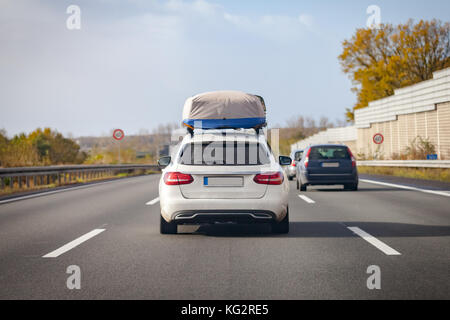 white car with porter drives on a german motorway Stock Photo
