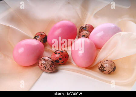 pink Easter eggs lying on a silk fabric. Stock Photo