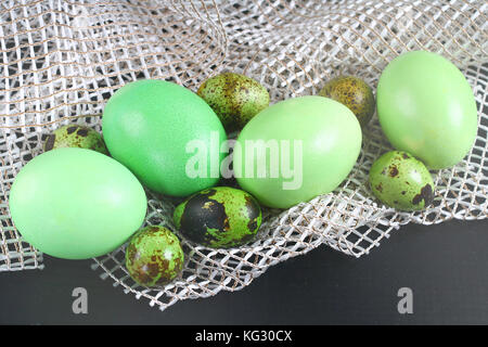 green easter eggs lie on white cloth. Stock Photo