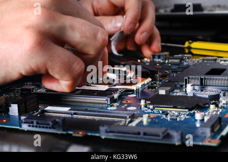 Computer literacy repair men hands, man examines laptop clean thermal paste Stock Photo