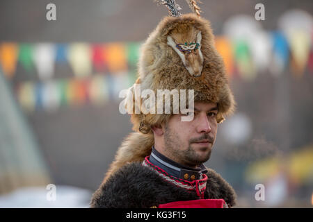 PERNIK, BULGARIA - JANUARY 27, 2017: Male participant in special costume is carrying scary fur brown hat made to chase evil away at Surva, the Interna Stock Photo