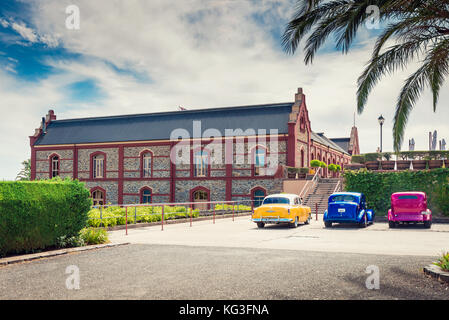 Adelaide, Australia - January 16, 2016: Vintage colourful cars parked near Chateau Tanunda winery on a bright day, viewed from main entrance. Stock Photo