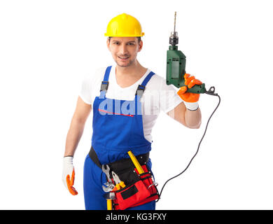 Smiling handyman wearing a hardhat and tool belt holding up his drill Stock Photo