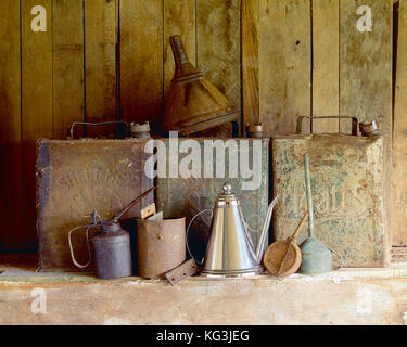 Still life. Antique petrol and oil cans on garage shelf. Stock Photo