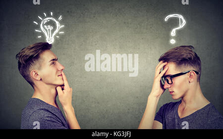 Two men thinking one has a question another solution with light bulb above head isolated on gray background. Stock Photo