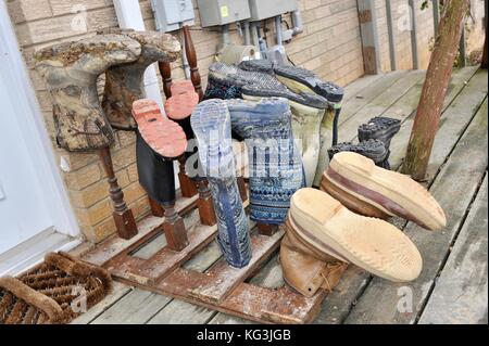 Boots on drying rack outside farmhouse at Wise Acres Organic Farm, a U-pick strawberry agriculture operation in Indian Trail, North Carolina, USA Stock Photo