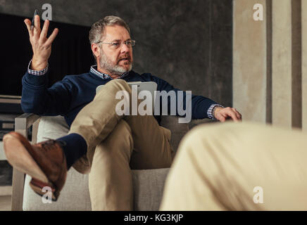 Psychologist talking with patient during the therapy.  Psychotherapist counseling client. Stock Photo