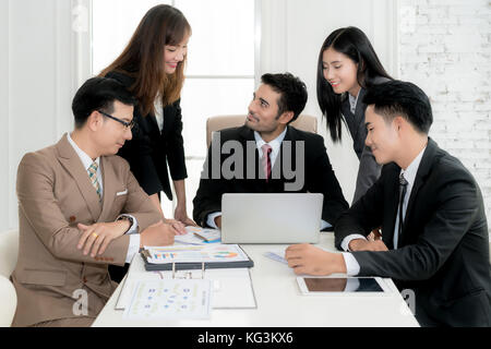 Group of multi-ethnic business partners discussing ideas in meeting room at office. Business people meeting corporate communication teamwork concept. Stock Photo