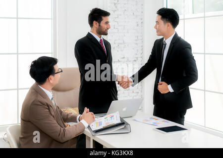 Asian businessman and partnership shaking hands in conference room. Business people shaking hands agreement concept. Stock Photo