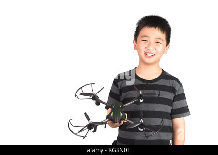 Asian boy holding hexacopter drone or quadrocopter toy in hand, studio shot isolated on white background. Stock Photo