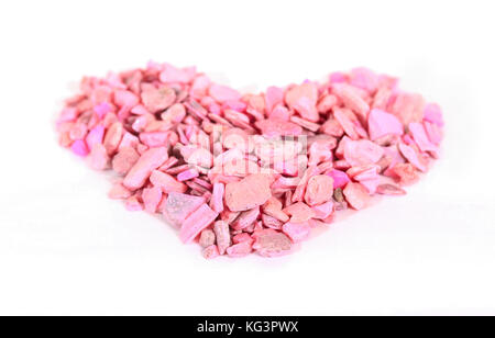 Heart from pink stones on white boards. The heart is laid out from small pink stones on the boards painted with white paint Stock Photo