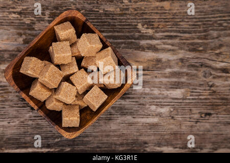 Bowl of brown sugaron an old wooden background, top view Stock Photo