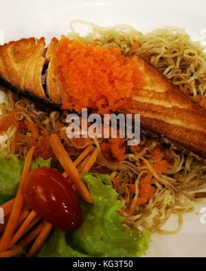 fried salmon with shrimp eggs (ebiko) on dry noodle plate fusion food Stock Photo
