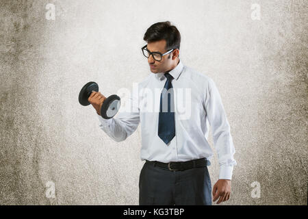 Young businessman lifting weights Stock Photo